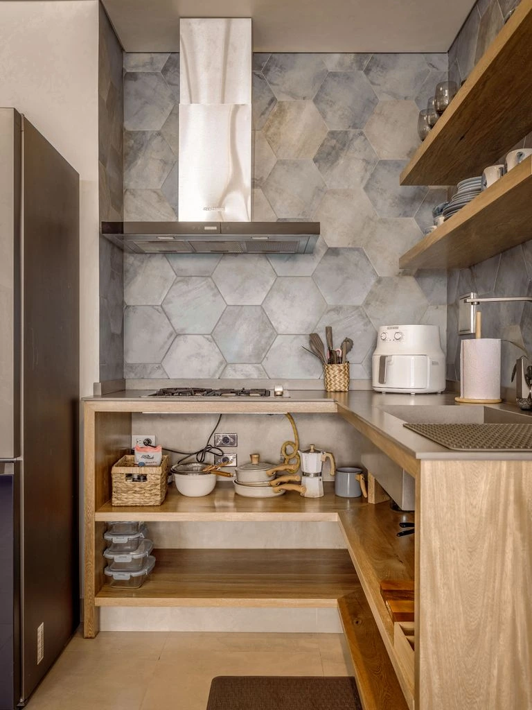 A budget rental kitchen with peel-and-stick backsplash and open shelving